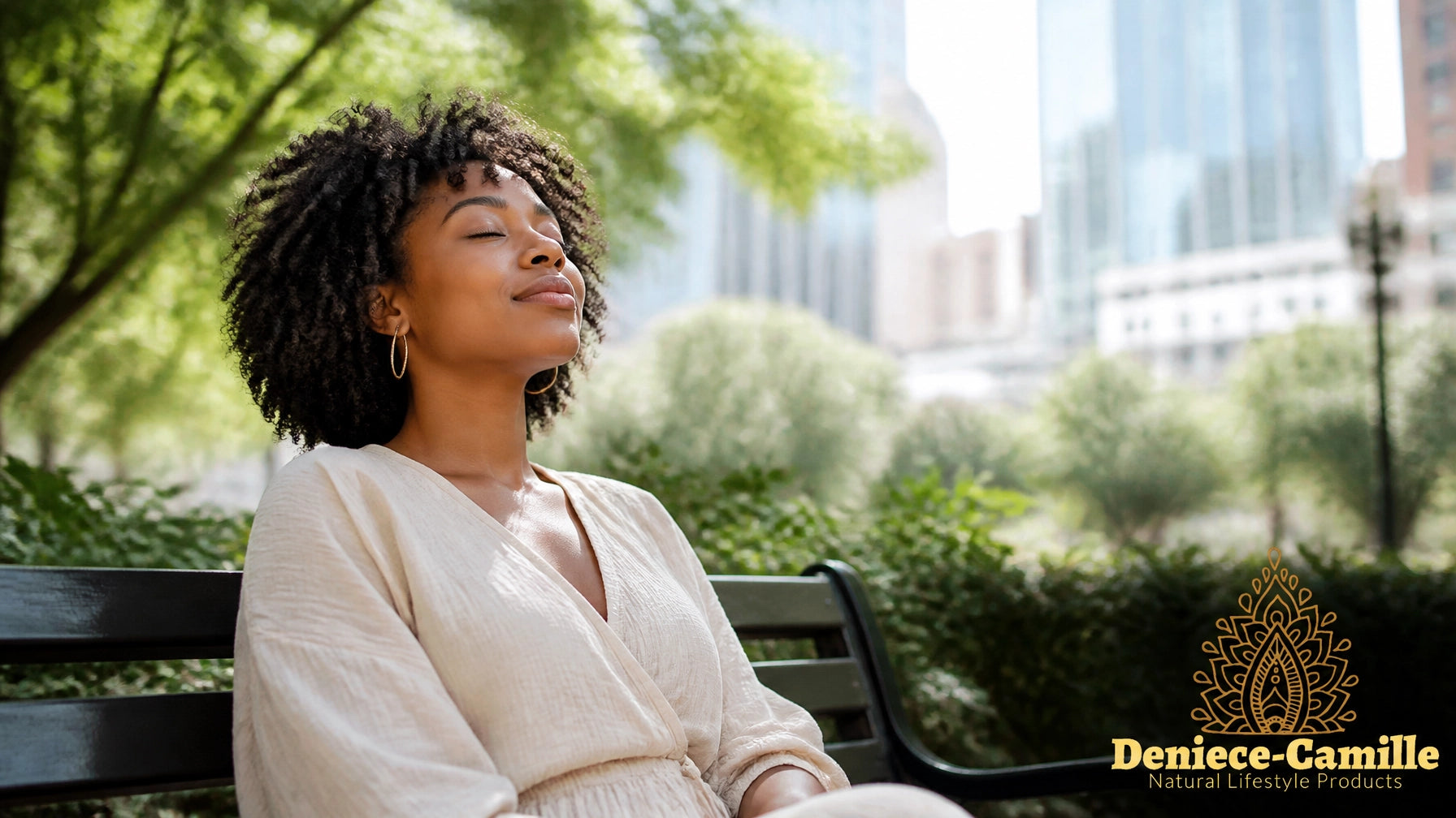 Serene African American woman sitting on a city bench in a sunny park, finding peace amidst the urban environment.